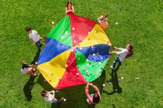 Children playing a parachute game outdoors